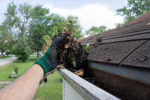 Cleaning Gutters Filled With Leaves Sticks