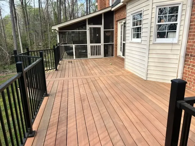 A wooden deck with black railings, designed by Charles & Associates.